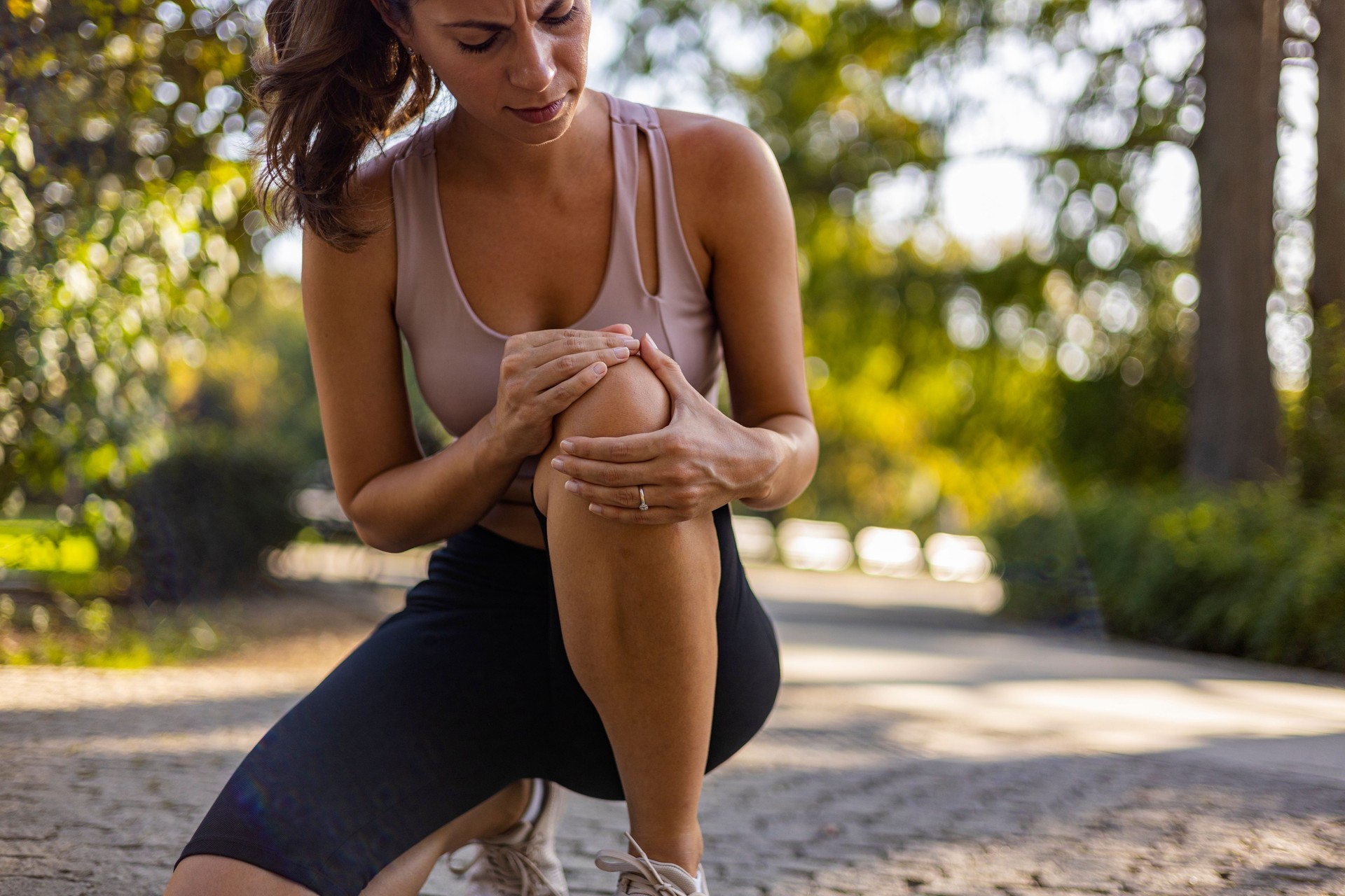 Young woman feeling pain in her knee.