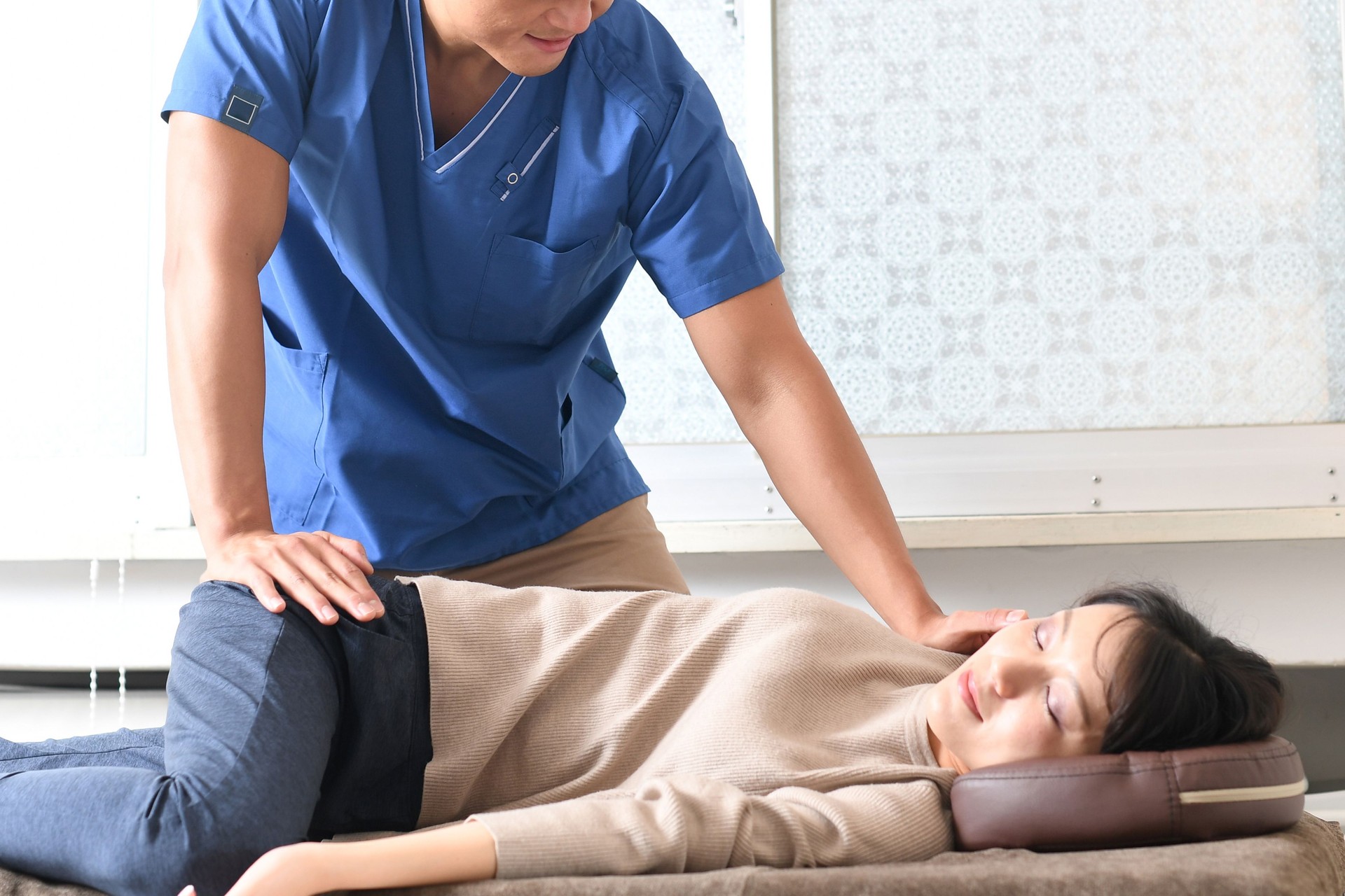 Chiropractor and Asian woman receiving treatment